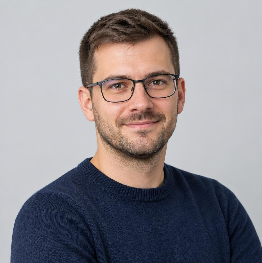 Studio portrait of a young Croatian man with short brown hair and glasses